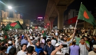 Bangladeshis wave national flags as they celebrate after the interim government officially banned all activities of the Awami League (AL) under the Anti-Terrorism Act, pending the conclusion of the International Crimes Tribunal (ICT) trials against the party and its leaders, in Dhaka on May 10, 2025. (Photo by MUNIR UZ ZAMAN / AFP)