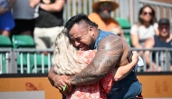Eddie Williams of Australia hugs his wife after competing in the Natural Stone Medley during the qualifying round at the 