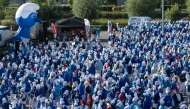 Participants wearing smurf (schtroumpf) costumes take part in an attempt to break the world record for the largest gathering of smurfs, in Landerneau, western France, on May 17, 2025. (Photo by Fred Tanneau / AFP)