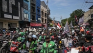 Drivers for ride hailing platforms, demanding a 10 percent cap on app commission charges amid high platform fees imposed onto them, demonstrate outside the Gojek office in Surabaya on May 20, 2025. (Photo by JUNI KRISWANTO / AFP)
