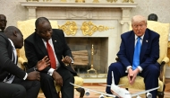 US President Donald Trump speaks as South African President Cyril Ramaphosa speaks with a member of his delegation in the Oval Office of the White House in Washington, DC, on May 21, 2025. (Photo by Jim WATSON / AFP)