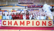 Al Rayyan players and officials celebrate with the trophy.