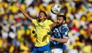 Pyramids' Egyptian midfielder #14 Mohanad Lasheen (R) jumps for the ball with Sundowns' South African forward #17 Tashreeq Matthews (L) during the first leg of the CAF Champions League final football match between Mamelodi Sundowns and Pyramids Football Club at Loftus Versfeld stadium in Pretoria on May 24, 2025. (Photo by Phill Magakoe / AFP)
