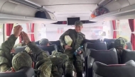 In this video grab taken from a handout footage released by the Russian Defence Ministry on May 24, 2025, a Russian prisoner of war (POW) reacts as he takes his seat in a bus following an exchange at an undisclosed location in Belarus. (Photo by Russian Defence Ministry / AFP)