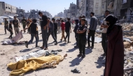 Graphic content / Palestinian stand over the shrouded bodies of people killed during an Israeli drone strike in Jabalia, in the northern Gaza Strip on May 23, 2025 (Photo by Bashar TALEB / AFP)
