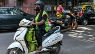 A rider leaves with customers' orders for delivery after collecting from a BigBasket dark store, in Mumbai. (Photo by Indranil Mukherjee / AFP)