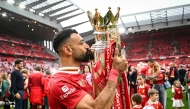 Liverpool's Egyptian striker #11 Mohamed Salah celebrates as he kisses the Premier League trophy at the end of the English Premier League football match between Liverpool and Crystal Palace at Anfield in Liverpool, north west England on May 25, 2025. (Photo by Paul Ellis / AFP)