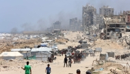 Palestinians transport their belongings as they flee the northern Gaza Strip toward the south, along the coastal al-Rashid road on May 25, 2025. (Photo by Omar Al-Qattaa / AFP)