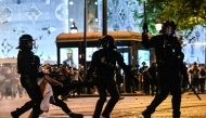 Anti-riot police officers detain a person as Paris Saint-Germain supporters celebrate after PSG won the UEFA Champions League final football match between Paris Saint-Germain (PSG) and Inter Milan held in Munich, on the Champs-Elysees avenue in Paris on May 31, 2025. (Photo by Lou Benoist / AFP)