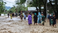 Residents wade through a flooded street following heavy rainfall in the Khurai Konsam Leikai village in Imphal East district of India's Manipur state on May 31, 2025. (Photo by AFP)