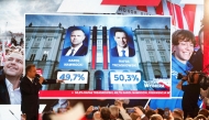 Preliminary results are displayed during the election night event showing the percentage of votes for presidential candidates, Karol Nawrocki and Rafal Trzaskowski, at the Mala Warszawa Theatre in Warsaw, Poland, on June 1, 2025. (Photo by Wojtek Radwanski / AFP)