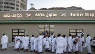 Muslim pilgrims wait outside a barbershop to receive a haircut in Mina on June 6, 2025. Photo by HAZEM BADER / AFP.