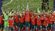 Portugal's forward #07 Cristiano Ronaldo (C) raises the trophy after winning the UEFA Nations League final football match between Portugal and Spain in Munich, southern Germany on June 8, 2025. (Photo by Alexandra BEIER / AFP)

