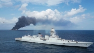 This handout photograph taken and released on June 9, 2025 by the Indian Navy shows smoke billowing from a cargo vessel that caught fire off Beypore coast in India's Kerala state. (Photo by INDIAN NAVY / AFP)