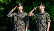 Jungkook (left) and Jimin of K-pop supergroup BTS salute at an outdoor sporting facility in Yeoncheon on June 11, 2025, shortly after their release from 18 months of South Korean military service. (Photo by Anthony Wallace / AFP)