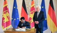Sri Lankan President Anura Kumara Dissanayake signs the visitor's book next to German President Frank-Walter Steinmeier during an official welcome ceremony at the presidential Bellevue Palace in Berlin, on June 11, 2025. (Photo by Tobias Schwarz / AFP)
