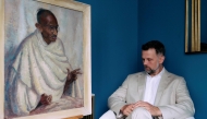 Caspar Leighton, great-nephew of British-American artist Clare Leighton, poses with a painting by his great-aunt of Indian independence leader Mahatma Gandhi at Bonhams auction house in London on June 9, 2025. (Photo by Benjamin Cremel / AFP)

