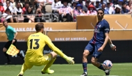 Paris Saint-Germain's Moroccan midfielder #02 Achraf Hakimi (R) passes the ball in front of Atletico Madrid's Slovenian goalkeeper #13 Jan Oblak during the Club World Cup 2025 on June 15, 2025. (Photo by Patrick T. Fallon / AFP)