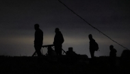 Palestinians gather in wait for the arrival of trucks carrying humanitarian aid near Jabalia, in the northern Gaza Strip late on June 15, 2025. Photo by BASHAR TALEB / AFP.