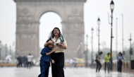 Girls walk along a road at the India Gate as it rains in New Delhi on June 17, 2025. (Photo by Arun Sankar / AFP)