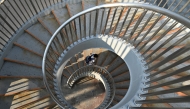 A schoolboy walks up spiral stairs to a walkway in Beijing on June 17, 2025. (Photo by Adek BERRY / AFP)
