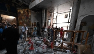 People and rescuers inspect the damage at the site of a reported suicide attack at the Saint Elias church in Damascus' Dwelaa area on June 22, 2025. (Photo by Louai Beshara / AFP)