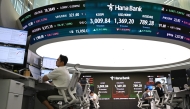 Currency dealers monitor exchange rates beneath a big screen showing South Korea's benchmark stock index (KOSPI) and the Korean won/USD exchange rate in a foreign exchange dealing room at the Hana Bank headquarters in Seoul on June 20, 2025. Photo by Jung Yeon-je / AFP.
