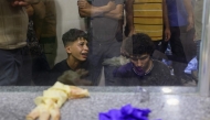 Palestinian youths mourn by the body of a relative killed in Israeli fire at a food aid distribution point set up by the privately-run Gaza Humanitarian Foundation (GHF) on the Salaheddin road, at Al-Awda hospital in the Nuseirat refugee camp in the central Gaza Strip on June 24, 2025. (Photo by Eyad BABA / AFP)
