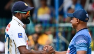Sri Lanka's Prabath Jayasuriya (L) and coach Sanath Jayasuriya celebrate Sri Lanka's win in the end of fourth day of the second Test cricket match against Bangladesh at the Sinhalese Sports Club (SSC) in Colombo on June 28, 2025. (Photo by Ishara S. Kodikara / AFP)
