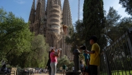 People refill their bottles at a public fountain in front of the Sagrada Familia basilica in Barcelona, on June 27, 2025, a day before the first heatwave of the year is officially expected to begin. (Photo by Manaure Quintero / AFP)