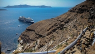 This file photograph shows a cruise ship arriving at the Greek island of Santorini while tourists on mules head to the village of Fira on July 19, 2024. Photo by ARIS OIKONOMOU / AFP