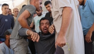 A Palestinian mourner breaks in tears during the funeral procession of people reportedly killed while waiting for aid delivery, outside al-Shifa hospital in Gaza City, on July 3, 2025. Photo by Omar AL-QATTAA / AFP