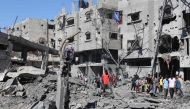 Palestinians inspect the damage after an Israeli strike in the Al-Bureij camp in the central Gaza Strip on July 4, 2025. (Photo by Eyad BABA / AFP)
