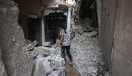 A Palestinian girl walks in the rubble of a building that was targeted in an Israeli strike in the Sheikh Radwan neighbourhood in Gaza City, in the central Gaza Strip on July 6, 2025. (Photo by Bashar TALEB / AFP)