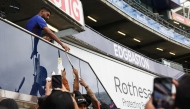 India's non-playing bowler Jasprit Bumrah signs autographs for fans, as rain delays the start of play on day five of the second cricket test match between England and India at Edgbaston cricket ground in Birmingham, central England on July 6, 2025. (Photo by Darren Staples / AFP) 
