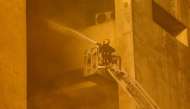 A firefighter douses the flames after a fire broke out in the Telephones landline exchanging station and Ministry of Communications building in the heart of Cairo on July 7, 2025. Photo by AFP