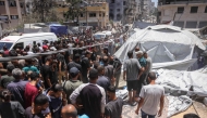 People check the site on an Israeli strike next to a tent housing displaced Palestinians, in Gaza City, on July 8, 2025. (Photo by BASHAR TALEB / AFP)
