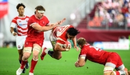 Japan's Shogo Nakano (C) is tackled by Wales' Taine Plumtree (R) during the international rugby union Test match between Japan and Wales at the Noevir Stadium in Kobe on July 12, 2025. (Photo by Philip FONG / AFP)

