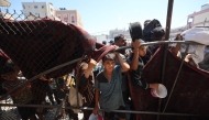 Palestinians gather at a food distribution point in the Nuseirat refugee camp in the central Gaza Strip on July 19, 2025. (Photo by Eyad BABA / AFP)
