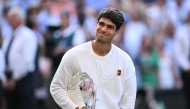 Spain's Carlos Alcaraz poses with the runner's up trophy, following his defeat against Italy's Jannik Sinner at the end of their men's singles final tennis match on the fourteenth day of the 2025 Wimbledon Championships at The All England Lawn Tennis and Croquet Club in Wimbledon, southwest London, on July 13, 2025. (Photo by Kirill KUDRYAVTSEV / AFP)