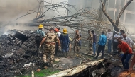 This handout taken and posted on the X (formerly Twitter) account of the Central Industrial Security Force (CISF) On June 12, 2025 shows rescue officials working at the site where Air India flight 171 crashed in a residential area near the airport in Ahmedabad. (Photo by Handout / CENTRAL INDUSTRIAL SECURITY FORCE (CISF) / AFP)