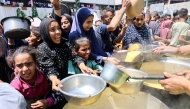 Displaced Palestinians receive lentil soup at a food distribution point in Gaza City in the northern Gaza Strip on July 25, 2025. (Photo by Omar AL-QATTAA / AFP)
