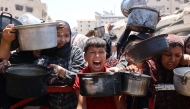 Palestinians crowd at a lentil soup distribution point in Gaza City in the northern Gaza Strip on July 27, 2025. (Photo by Omar AL-QATTAA / AFP)