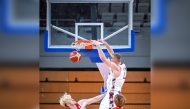 Qatar's Alen Hadzibegovic scores with a dunk against Japan.