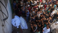 Palestinians pray by the bodies of people killed a day earlier while waiting for aid, during a funeral service at the Al-Shifa hospital in Gaza City on July 31, 2025. Photo by BASHAR TALEB / AFP