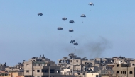 Aid pallets are parachuted after being dropped from a military plane over Nuseirat in the central Gaza Strip during an airdrop mission above the Israel-besieged Palestinian territory on August 4, 2025. (Photo by AFP)
