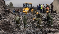 Rescuers work betwwen wreckage parts at a scene where a Kenyan medical plane crashed, killing at least 6 people, on the outskirts of Nairobi on August 7, 2025. (Photo by SIMON MAINA / AFP)
