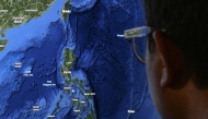 This photo illustration shows a man looking at a map on a computer screen in Manila on April 14, 2025. Photo by Jamillah STA. ROSA / AFP