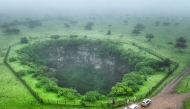 An aerial picture shows a view of the Sheeheet sinkhole in Oman's Dhofar region near the city of Taqah on July 25, 2025. (Photo by AFP)
