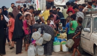 Palestinians queue to fill up on drinking water in the sweltering heat in the Mawasi area of Khan Yunis in the southern Gaza Strip on August 12, 2025. (Photo by AFP)
